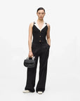 MiLA Boutique black sleeveless knit top with white collar and gold buttons, paired with black trousers.