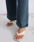MiLA Boutique cream leather square-toe thong sandals with a 4cm lacquered heel, worn with denim.