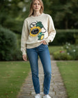 MiLA Boutique cream knit sweater with embroidered sunflower, peace sign, and heart details.
