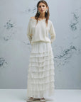 MiLA Boutique cream V-neck sweater with raglan sleeves and slip-stitch detailing, worn by a model with a ruffled white skirt.