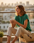 MiLA Boutique emerald green knit short sleeve sweater on a woman sitting outdoors with a coffee cup.