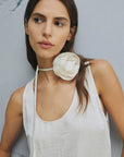 MiLA Boutique white crinkle twill sleeveless top with rounded neckline and fabric flower choker detail.