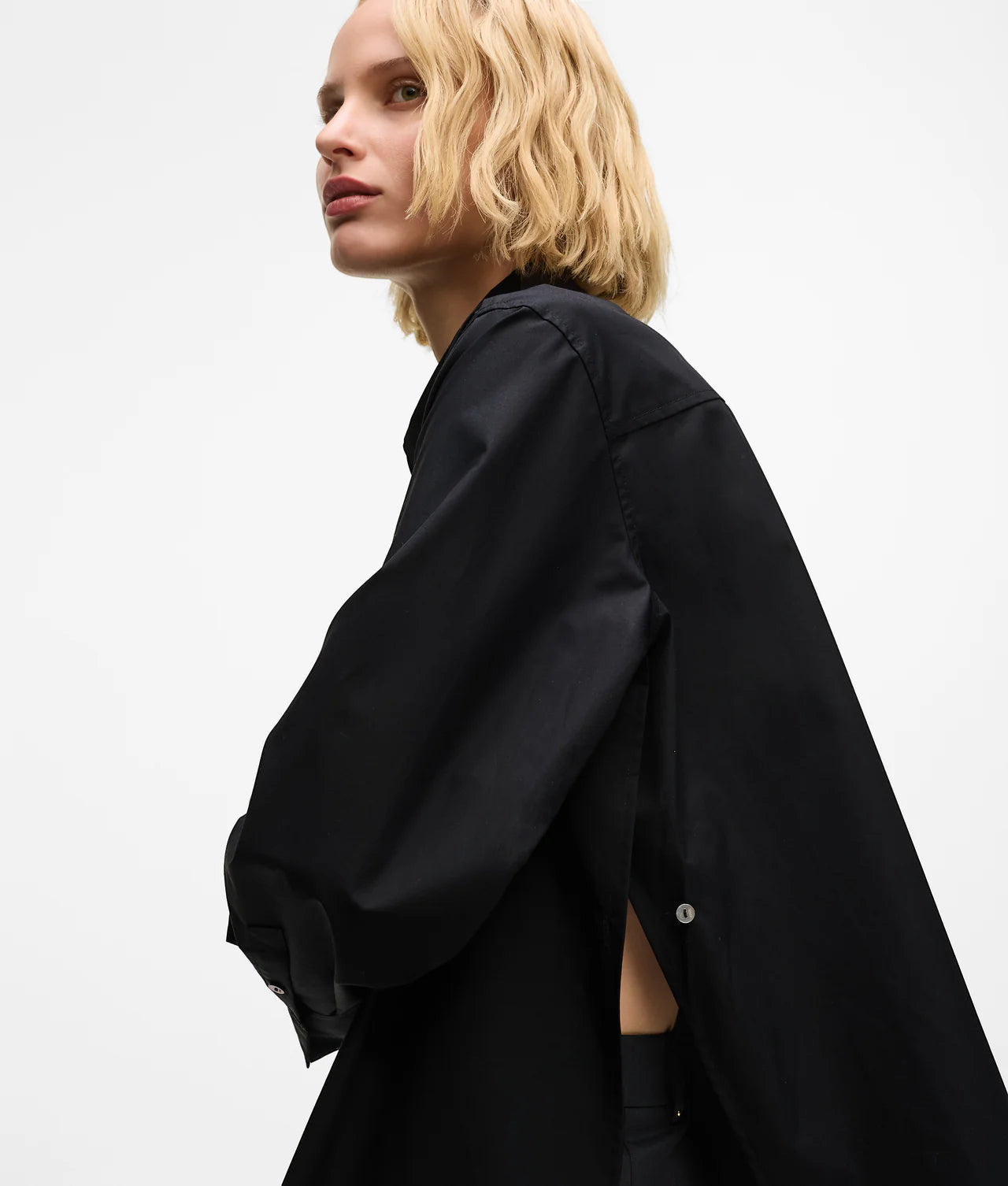 MiLA Boutique black cotton shirt with pointed collar, split side seams and button details. Model is wearing the shirt.