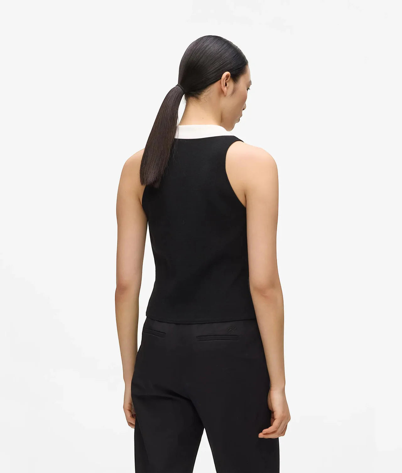 MiLA Boutique black sleeveless knit top with white collar and gold button detail, worn by a model.