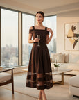 MiLA Boutique off-the-shoulder midi dress in rich brown with lace trim at the hem. Fitted bodice, pleated skirt, elegant evening wear.