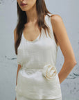 MiLA Boutique cream crinkle twill sleeveless top with rounded neckline and fabric flower accent.