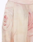 MiLA Boutique wide-leg satin trousers with a delicate rose print in soft pink and cream hues. Features include pleats and a smooth, flowing drape.