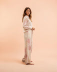 Blugirl Blumarine wide-leg satin trousers with a delicate rose print, elasticated waistband, and drawstring. Beige with pink floral design.