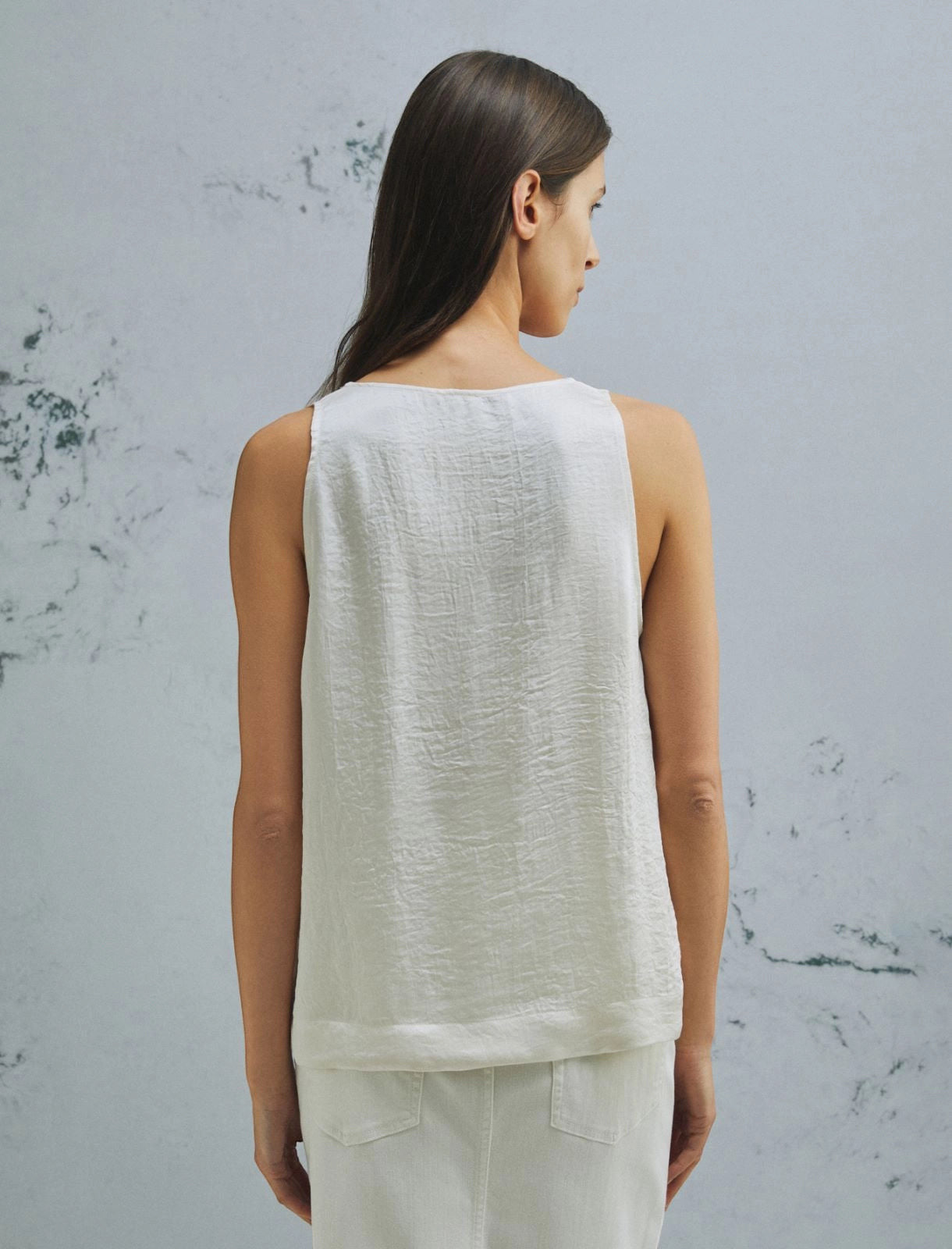 MiLA Boutique white crinkle twill sleeveless top with rounded neckline and side slits, paired with white denim skirt.