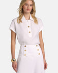 MiLA Boutique white linen polo shirt with gold buttons, cap sleeves, and turn-up cuffs.